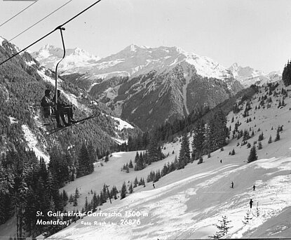 Ein Bild von der Garfreschabahn in Richtung Gaschurn ca. um 1970. Skifahrer sitzen auf einem Sessel.