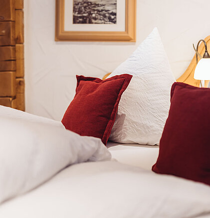 Detailsfoto von den Kissen auf dem Bett im Doppelzimmer Heimatnest im Genusshotel Vermala