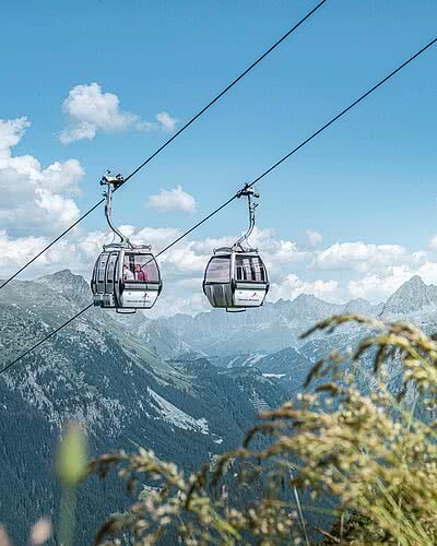 Versettla Bahn im Montafon mit Gondeln, Sommerlandschaft und Panoramablick auf die Bergwelt.