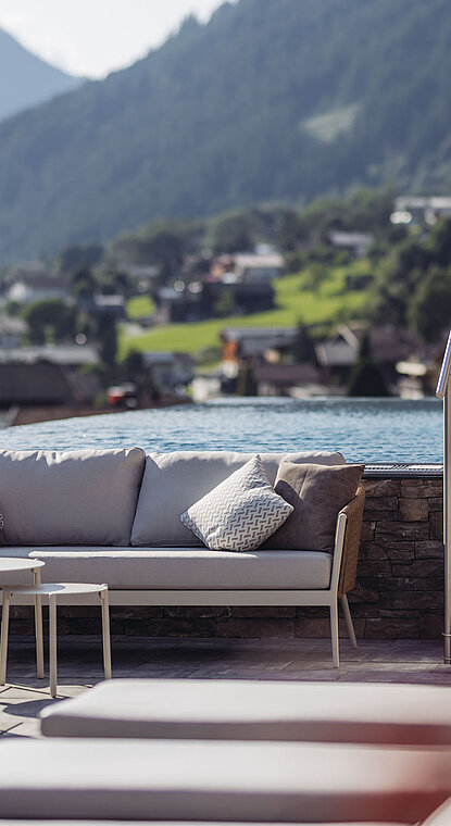 Sitzbereich und Sky Pool im Genusshotel Vermala mit Panoramablick auf die Montafoner Landschaft.
