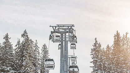 Valisera Bahn in St. Gallenkirch im Winter mit Gondeln, verschneiten Bäumen und Skigebiet Silvretta Montafon.