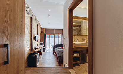 Suite Brunella im Genusshotel Vermala mit Blick vom Eingangsbereich zum Schlafbereich und Badezimmer.