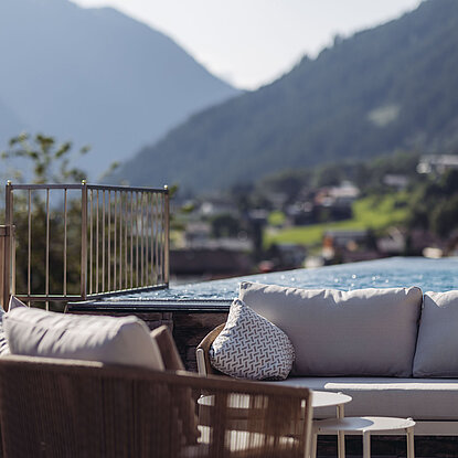 Montafoner Nature SPA Sitzbereich am Sky Pool des Genusshotel Vermala mit Lounge-Möbeln und Aussicht auf das Montafon.