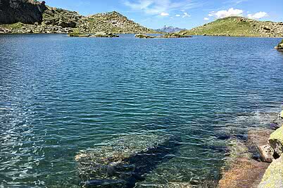 Oberer Vallülasee im Montafon mit klarem Bergsee, Felsen und alpiner Hochgebirgslandschaft.