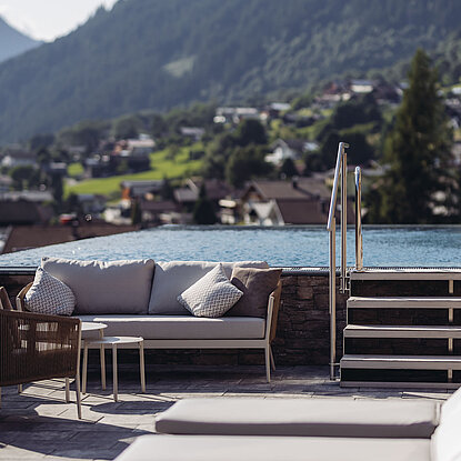 Liegebereich im Genusshotel Vermala mit Sky Pool, Stufen und Blick auf St. Gallenkirch im Montafon.