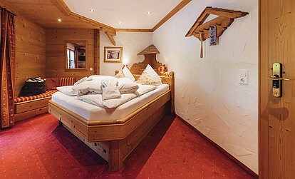 Zimmer Heimatliebe im Genusshotel Vermala in St. Gallenkirch mit Doppelbett, Holzinterieur und gemütlicher alpiner Einrichtung.