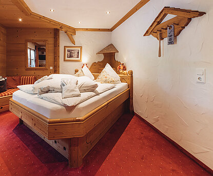 Zimmer Heimatliebe im Genusshotel Vermala in St. Gallenkirch mit Doppelbett, Holzinterieur und gemütlicher alpiner Einrichtung.