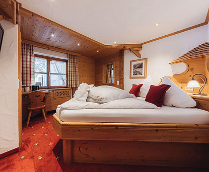 Zimmer Heimatnest im Genusshotel Vermala in St. Gallenkirch mit Doppelbett, Holzinterieur und gemütlicher alpiner Einrichtung.