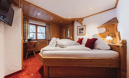 Zimmer Heimatnest im Genusshotel Vermala in St. Gallenkirch mit Doppelbett, Holzinterieur und gemütlicher alpiner Einrichtung.