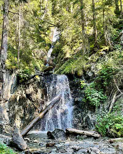 Wasserfall am Gretsch im Montafon mit Wald, Felsen und natürlicher Wasserkulisse.